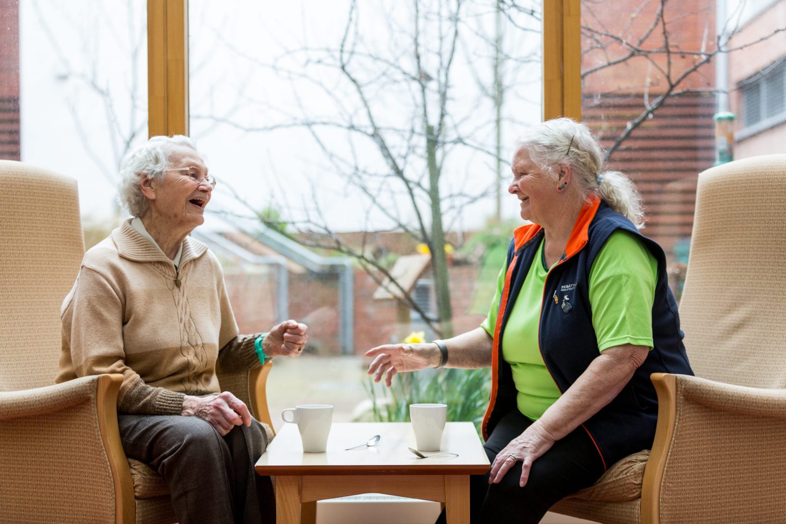 Two women chatting over cups of tea